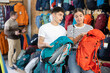 © JackF - Young married couple chooses backpack for summer hike in a tourist equipment store