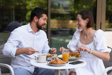 Canvas Print - Happy couple having breakfast in outdoor cafe