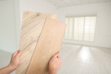 Sticker - Man with samples of wooden flooring indoors, closeup. Space for text