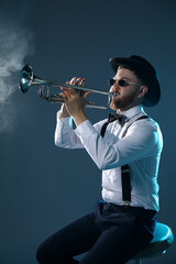 Sticker - Professional musician playing trumpet on dark background