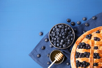 Wall Mural - Tasty homemade pie with blueberries served on blue table, flat lay. Space for text