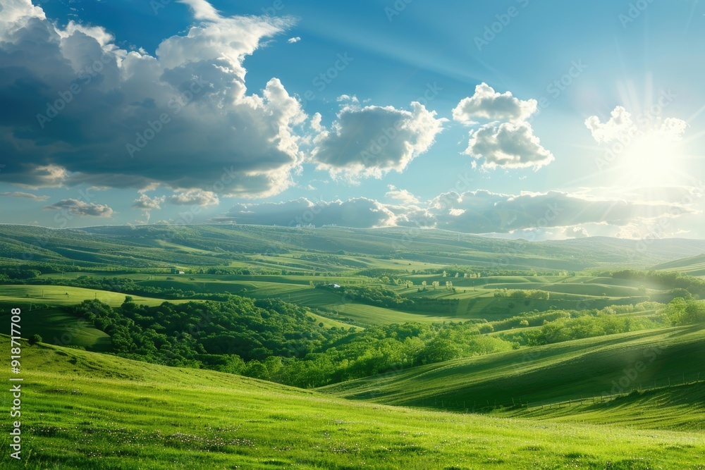 The sun breaks through the clouds over rolling green hills, a serene ...