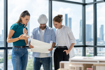 Wall Mural - Group of architect engineer looking at project plan while brainstorming idea about building structure. Manager team discuss about building construction while standing near with city view. Tracery.