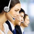 © vgstudio - Contact center servise concept image. Call centre phone operators working at workplace together. Blurred modern office background. Wide banner composition with copy space free area.