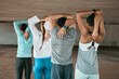 © Haas/peopleimages.com - Group, people and city for stretching arms with runner, workout and diversity in underground parking lot. Women, man and friends with warm up for exercise, muscle and wellness for fitness in metro
