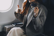 © ARMMY PICCA - Young businesswoman holding credit card near blurred devices in private plane