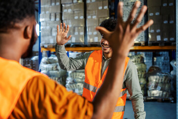 Wall Mural - Diverse supervisor and warehouse worker greeting and preparing to clap hands. Team of experienced workers collaborating