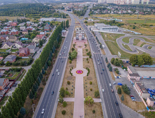 The aerial photo of Victory Memorial park in Kursk, Russia, with the World War II Triumphal Arch, the residential houses, and the highway.
