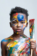 Sticker - A young boy with his face painted with colorful paint and holding a paintbrush.