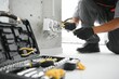 © Serhii - An African electrician installs electrical outlets at a construction site