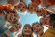 © Kevin - Bunch of cheerful joyful cute little children playing together and having fun. Group portrait of happy kids huddling, looking down at camera and smiling. Low angle, view from below. Generative AI