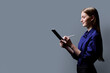 © Valerii Honcharuk - College student girl using digital tablet, profile view, gray background