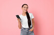 © New Africa - Smiling woman with smartphone on pink background