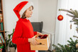 © Westend61 - Girl holding wooden box filled with Christmas ornaments at home