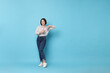 © New Africa - Happy woman pointing at something on light blue background. Space for text