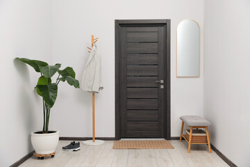 Sticker - Coat rack, houseplant and shoe storage bench in hallway. Interior design