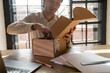 © Westend61 - Businessman unboxing package at desk