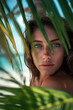 © ArtmediaworX - Sexy beautiful woman posing in the tropical beach next to a palm tree. Ai Generative