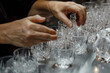 © Татьяна Евдокимова - Bartender is polishing crystal glasses on a bar, preparing for a busy night serving customers