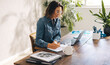 © Jacob Lund - Businesswoman writing notes during online meeting