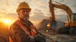 © Naknakhone - Handsome happy professional excavator driver standing in front of big excavator looking at camera at sunrise. copy space for text.