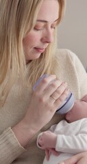 Sticker - Milk, bottle and a woman feeding her baby in a bedroom of their home together for love, growth or care. Family, nutrition or formula and a newborn infant drinking with a single parent in apartment