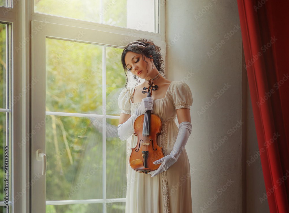 Fashion model woman violinist posing holding in hands wooden violin ...
