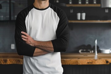 Wall Mural - A person standing in a kitchen with their arms crossed, ready for conversation or contemplation