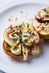 Wall Mural - Toasts with pesto, brie, dorblu, fig and pistachio.