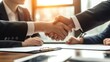 © elimicel - Close up of business people negotiating a contract and shaking hands in agreement during a meeting