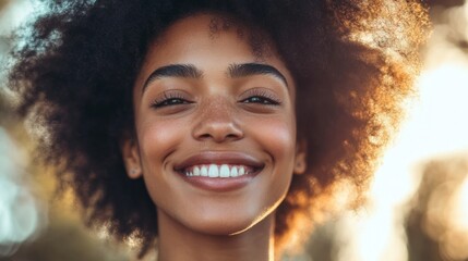 Wall Mural - A woman with curly hair is smiling and looking at the camera