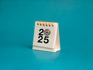 Poster - happy new year 2025 background. 2025 number with target dart icon on white small desk calendar cover