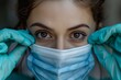 © Olsek - Close-up portrait of a person adjusting a surgical face mask. The individual wears gloves and the focus is on their intense eyes. Perfect for health-related content, medical articles, or blogs. AI