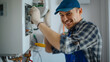 © Lahiru - A heating engineer is repairing a boiler in a house. Boiler repair services or installation, HVAC, central heating system, gas heating house concepts.