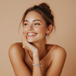 © BetterPhoto - Happy woman wearing earrings and a bracelet, smiling with a cheerful expression, representing joy and elegance in a studio setting.