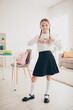 © deagreez - Vertical photo of cute small schoolkid show heart wear uniform living room apartment indoors