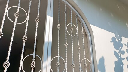 A window with a white frame and a lot of decorative ironwork