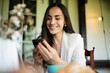 © My Ocean studio - Modern successful independent confident beautiful business woman in a smart business suit using her phone sitting at a table in a summer city cafe in a good mood