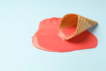 Wall Mural - Melted ice cream and wafer cone on light blue background