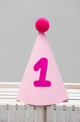 Wall Mural - pink cardboard hat with pompom for birthday 1 year old