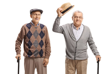 Wall Mural - Senior men with walking canes, one greeting with his hat