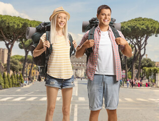 Wall Mural - Male and female city tourists with backpacks standing in Rome