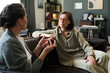 © Mediaphotos - Two women are intently discussing mental health in a counseling session Both are seated on a comfortable couch in a cozy, well-decorated room surrounded by books and personal items