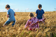 © Irina Schmidt - Three children having fun on yellow wheat field in summer on summer day. Two brother boys and little sister girl. Active outdoors leisure for family. Kids playing together.