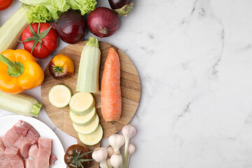 Wall Mural - Different vegetables and raw meat for stew on white marble table, top view. Space for text