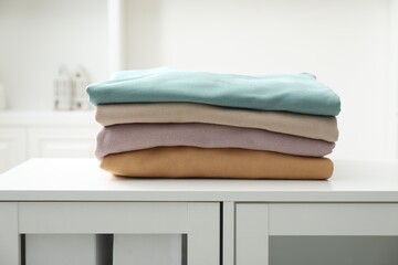 Sticker - Stack of clean clothes on white dresser indoors