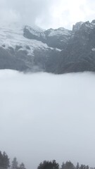 Wall Mural - Fly over majestic mountain peaks and a fog. Creative. Valley covered by clouds and mountains on the background.