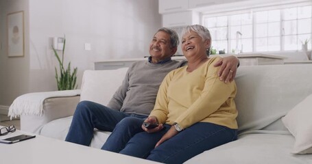 Poster - Senior couple laughing while watching tv and relaxing on couch together at home. Mature husband and wife enjoying a funny movie while bonding and being affectionate, embracing and having fun indoors