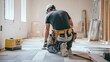 © fivan - A construction worker installing tile flooring in a new home