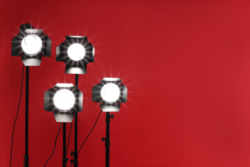 Wall Mural - Red photo background and professional lighting equipment in studio, space for text